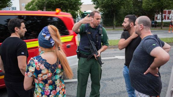 Un policía, hablando con varios ciudadanos.