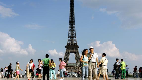 Un grupo de turistas chinos en la Torre Eiffel.