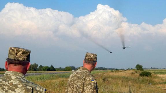 Dos soldados ucranianos observan el vuelo de dos bombarderos en Ucrania. 