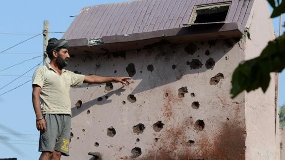 Un ciudadano indio muestra los daños causados en su vivienda por los disparos en la frontera. 