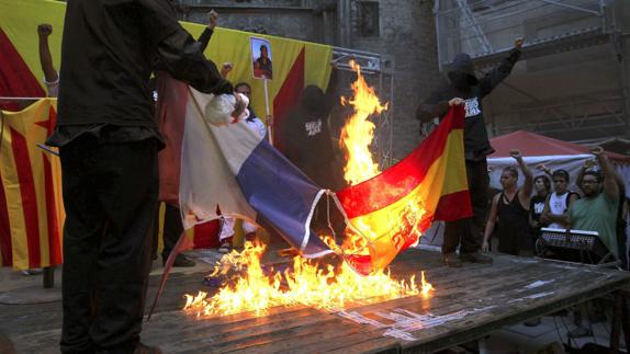 Manifestantes queman una bandera de España y otra de Francia durante la Diada