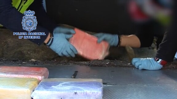 Los agentes recogen los bloques de cocaína del interior de un vehículo.