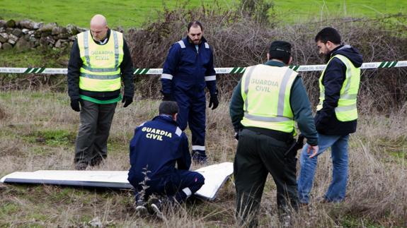 Agentes de la Guardia Civil inspeccionan la parte de la cola de la avioneta.