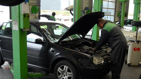 Mecánico revisa el motor de un coche.