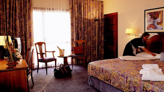Camarera realiza la cama en un hotel de Marbella.