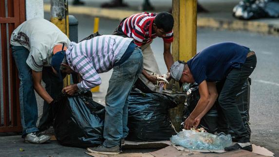 Varias personas buscan en la basura de Caracas. 