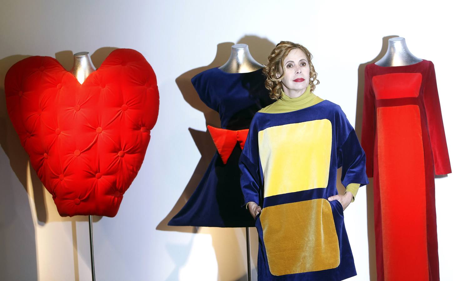 La diseñadora Agatha Ruiz de la Prada posa frente a varios de sus diseños en la inauguración de la exposición 'Agatha Ruiz de la Prada: 55 formas de vestir el color'