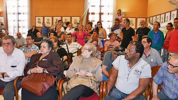 Al fondo, vecinos que han ocupado pisos de La Coma, pidiendo ayudas en el último pleno. 