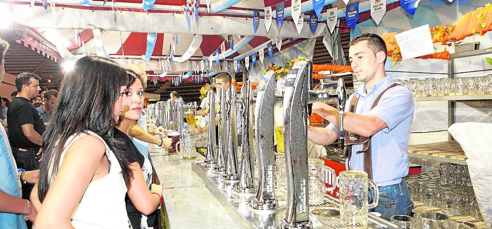 Unas jóvenes piden su cerveza en una de las barras.