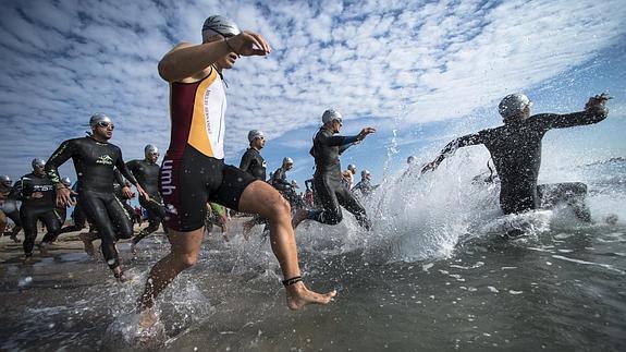 Los participantes inician el tramo de natación en el Traitlón de Pinedo celebrado esta mañana. 