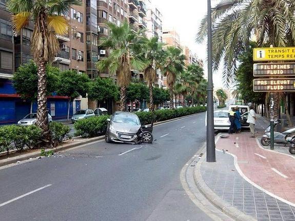 En la foto, uno de los coches accidentados, y Alborch saliendo de su vehículo ayudada por un agente.