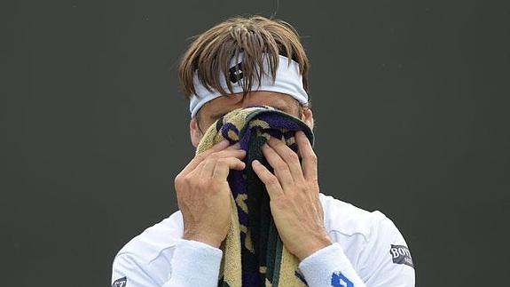 Ferrer se seca la cara durante un descanso entre juegos, en el partido con Kuznetsov.