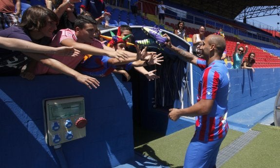 Rafael Martins regala las botas a unos aficionados. 