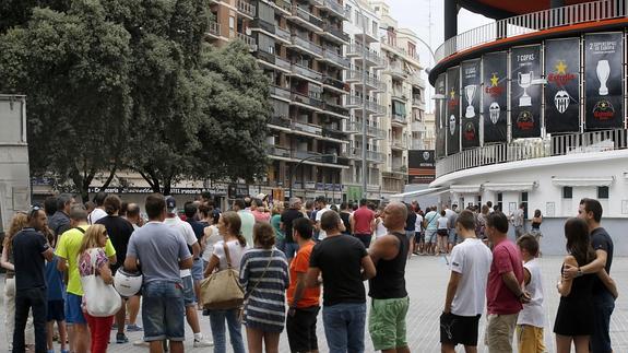 Un numeroso grupo de aficionados guarda cola ante las taquillas del estadio de Mestalla para adquirir entradas para el partido entre el Valencia y el Milan en la 43 edición del trofeo Naranja