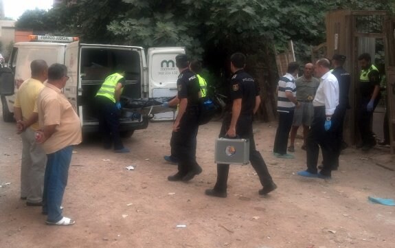 Dos empleados del retén fúnebre introducen el cadáver del anciano en el furgón. :: j. martínez