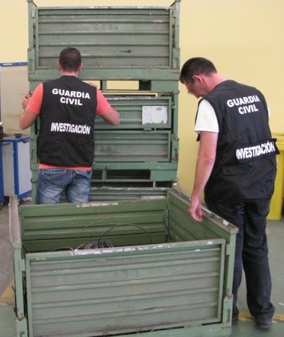 Dos agentes inspeccionan los contenedores recuperados. :: lp