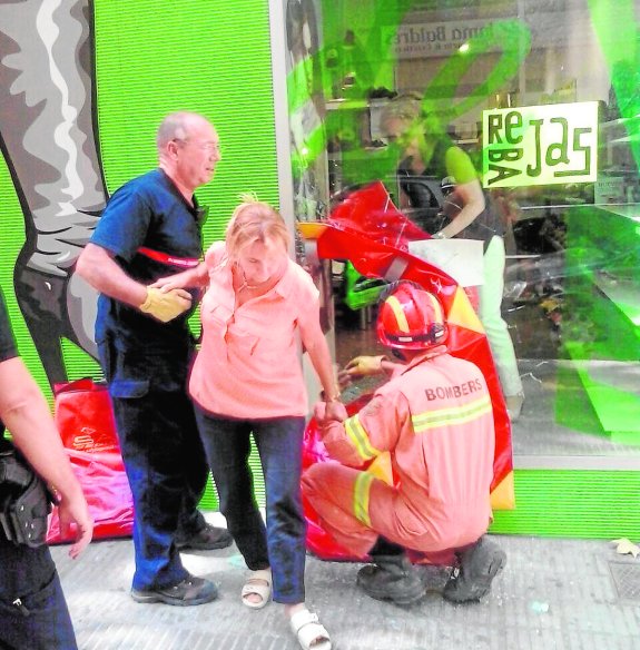 Una clienta sale de la tienda con la ayuda de los bomberos. :: bombers twitter