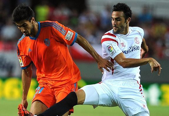 André Gomes y Vicente Iborra pelean por el balón