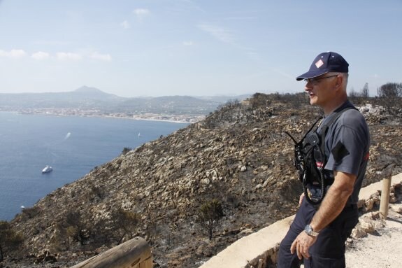 Un bombero observa el parque natural quemado desde un mirador del cabo de San Antonio. :: tino calvo