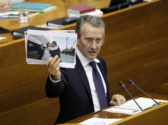 El portavoz socialista, Antonio Torres, muestra una foto de Castedo y Fabra saludándose.