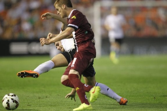 Paco Alcácer cae en la lucha por el balón con un jugador del Córdoba. :: damián torres