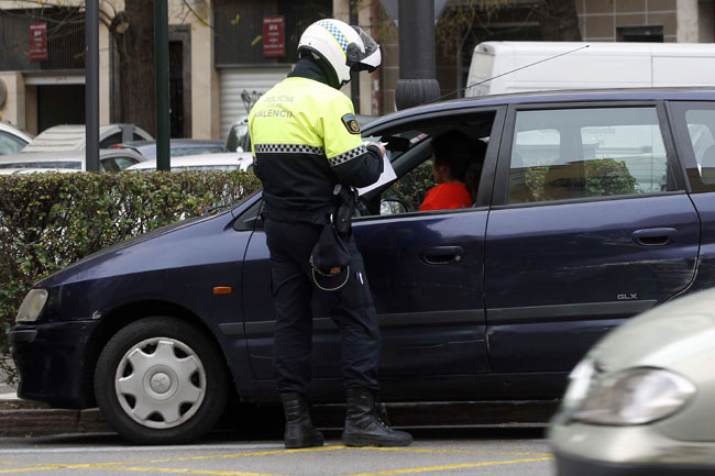 Un policía pone una multa a un conductor.