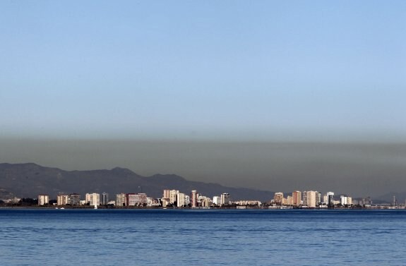 La playa de la Malvarrosa, con una capa de niebla de color marrón. :: jesús signes