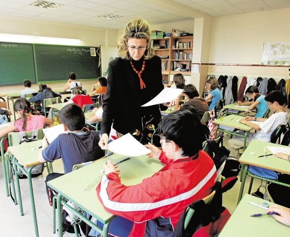 Una maestra reparte pruebas de examen entre sus alumnos. :: Sergio Barrenechea / EFE