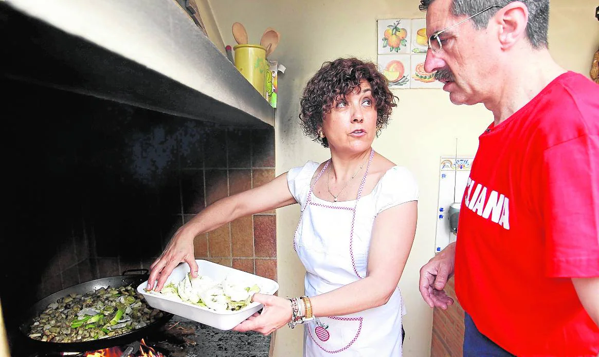 Carmen Ninet prepara una paella bajo la atenta mirada de su marido, José María Ángel.
