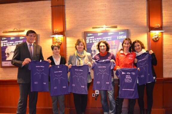 Organizadores y atletas muestran la camiseta de la carrera. :: lp