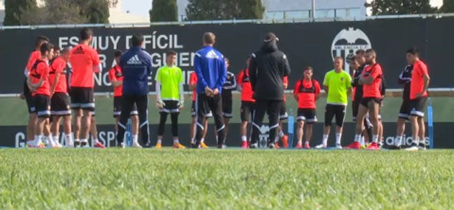 Los jugadores del Valencia atendiendo a Nuno antes del entrenamiento.