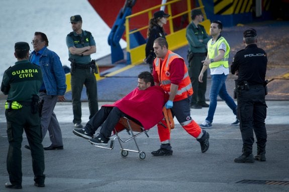 Un miembro de Cruz Roja traslada a una de las personas que fueron evacuadas tras el incendio del ferry. ::  AFP PHOTO / JAIME REINA