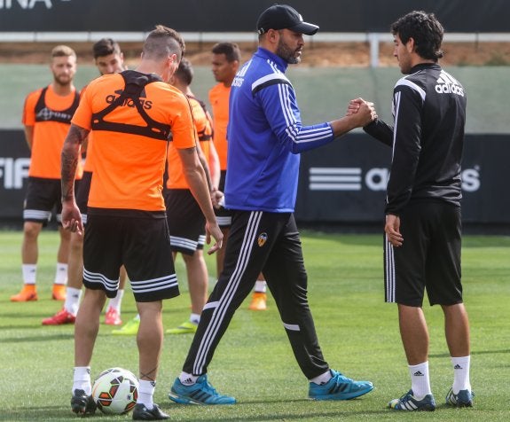 Nuno saluda a Parejo en el entrenamiento de ayer.