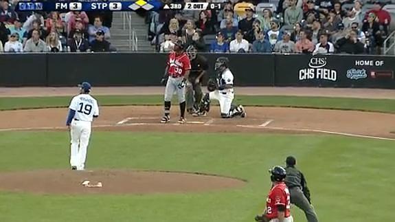 Un espectador atrapa un bate que sale disparado en pleno partido de béisbol