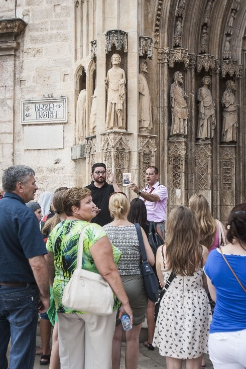 Un grupo de turistas con guía en la puerta de los Apóstoles de la Catedral de Valencia.:: jesús montañana