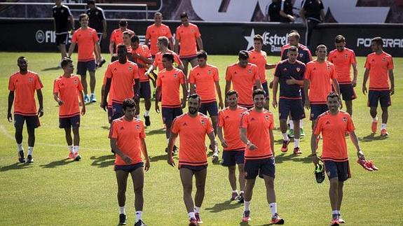 Los jugadores del Valencia abandonan el campo tras el entrenamiento.