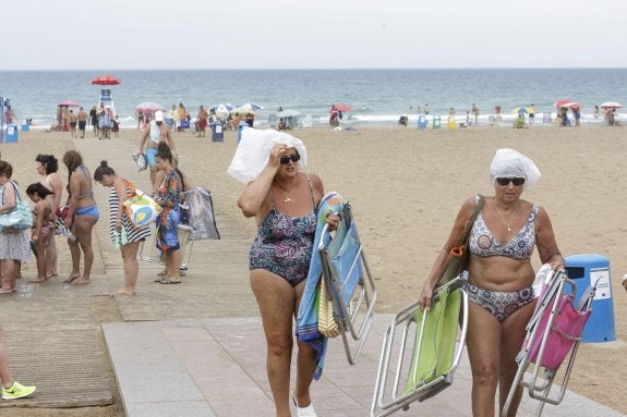 Bañistas abandonan la playa de Gandia por el chaparrón de ayer. :: EFE/Rubén Francés