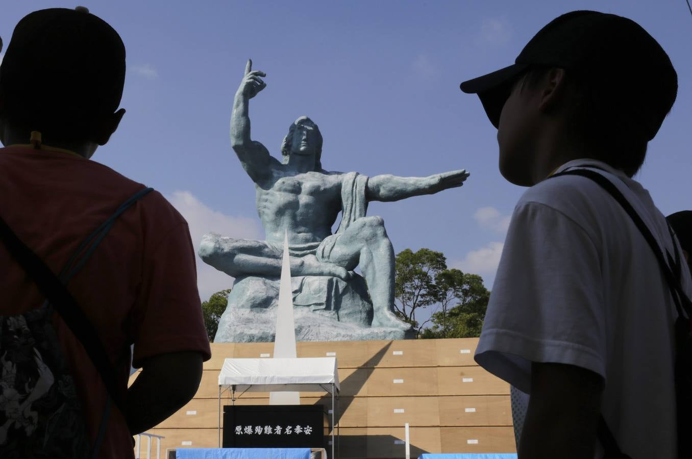 Dos jóvenes observan el monumento conmemorativo.