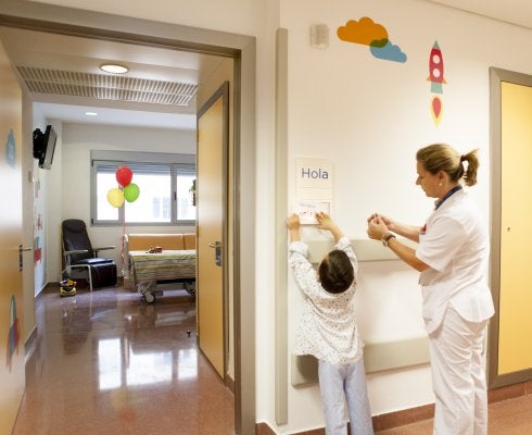 Una enfermera ayuda a un pequeño paciente a colocar un cartel.:: LP