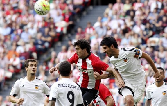 Paco Alcácer presencia la lucha entre Dani Parejo y Mikel San José por un balón aéreo. :: efe/luis tejido