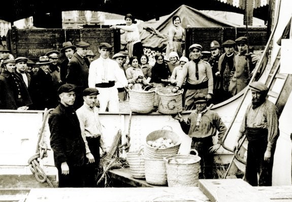 NARANJAS
Estibadores, encajadoras, exportadores y policías posan en 1915 mientras cargan un barco con naranjas en el puerto de Valencia. :: lp