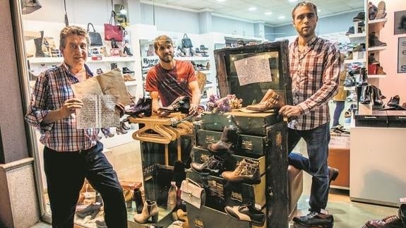 Los Polo, padre e hijos, con el baúl, la joya del escaparate de su zapatería en Montijo (Badajoz).