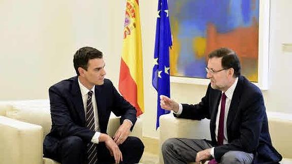 El presidente del Gobierno, Mariano Rajoy (D), durante una reunión con el Secretario General del Partido Socialista, Pedro Sánchez (i).