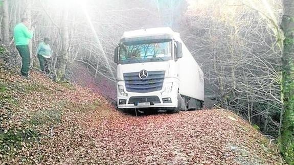 El camión, cargado con 22 toneladas de fruta, en la ruta forestal en la que terminó atrapado.