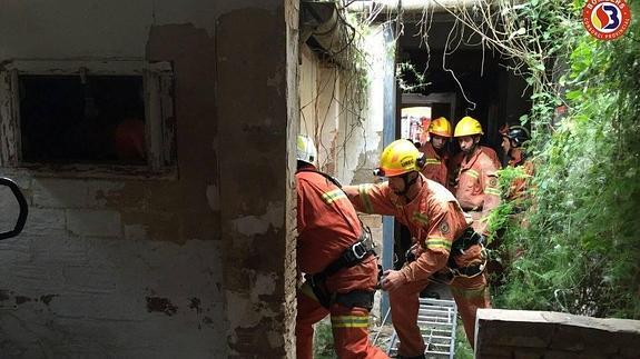 Los bomberos en la vivienda en la que ha sido hallada la anciana.