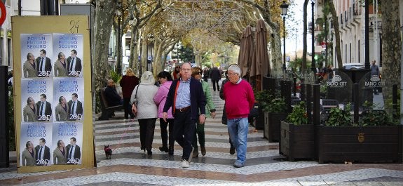 Vecinos de Gandia caminan por el paseo de las Germanías, donde Torró ha colocado sus propios carteles. :: chris lennol
