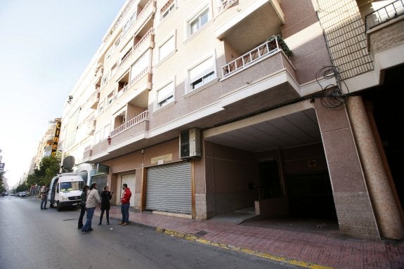 Un grupo de vecinos, ayer, reunidos junto a la finca de Torrevieja donde fueron descubiertos los tres cuerpos sin vida. :: EFE/Manuel Lorenzo