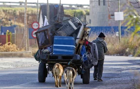 Un hombre arrastra un carro repleto de chatarra, este viernes, por el polígono Coscollar de Aldaia.