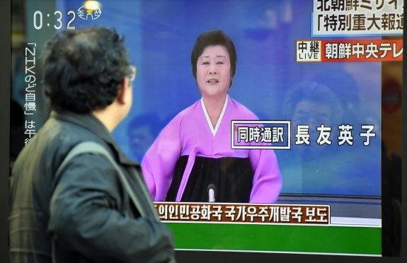 Un peatón mira una pantalla callejera con Ri Chun-Hee. :: afp