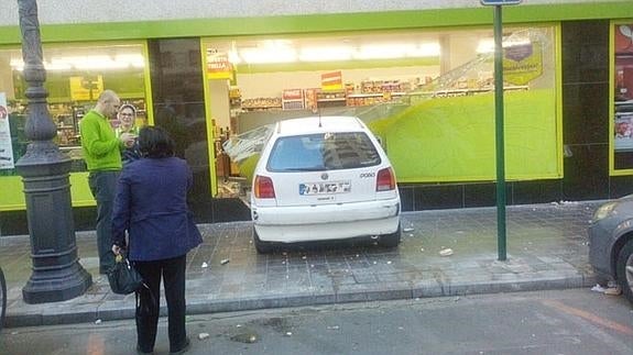 El coche blanco, con la parte delantera dentro del establecimiento en Valencia.